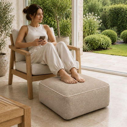 Inflatable square ottoman used as a footrest beside a living room sofa