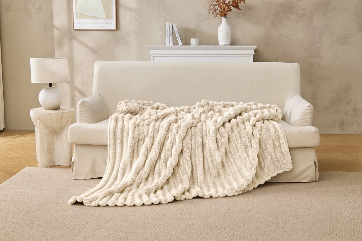 Grey ribbed fleece throw layered on a bed as a bedspread
