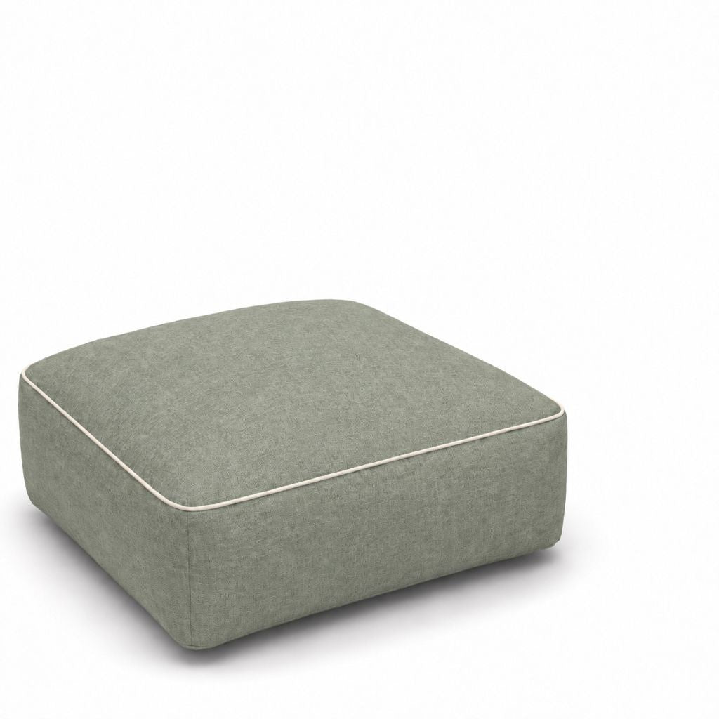 Person resting feet on the inflatable ottoman beside a sofa
