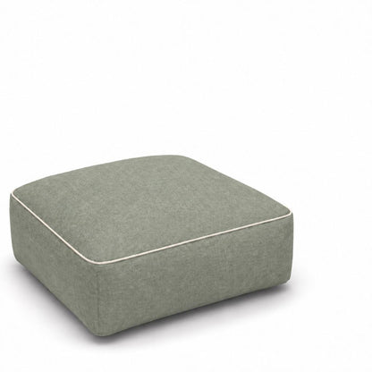 Person resting feet on the inflatable ottoman beside a sofa
