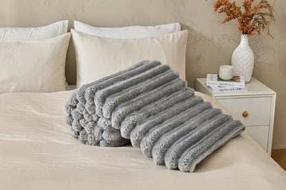 Black ribbed fleece throw blanket on a contemporary bed