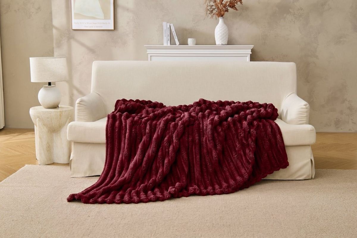 Chunky fleece throw layered with cushions on a corner sofa