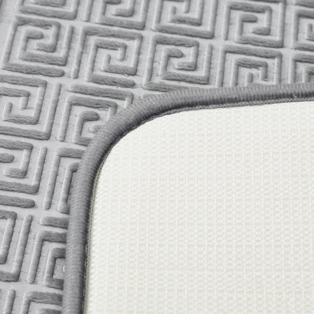 Absorbent plush surface of Greek key bath mat soaking up water