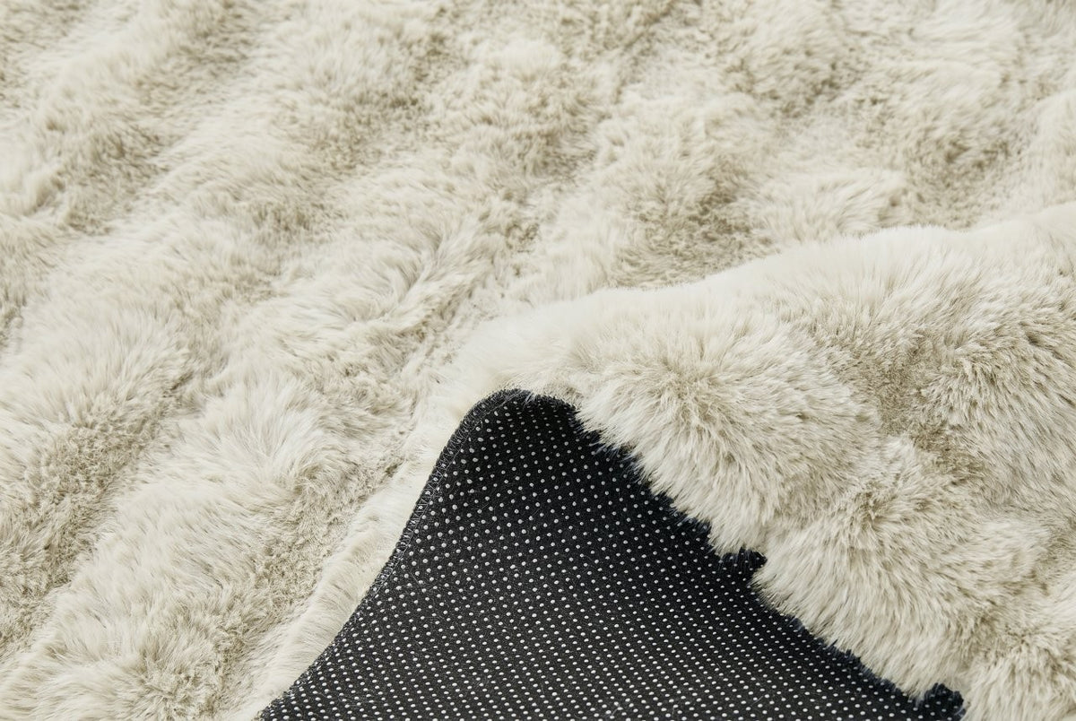 Shaggy faux fur rug used as a bedside mat