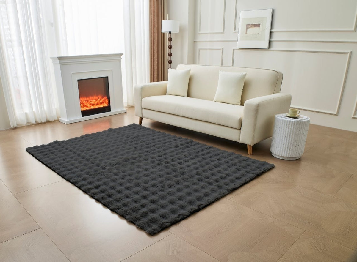 Grey shaggy faux fur rug shown in a modern lounge