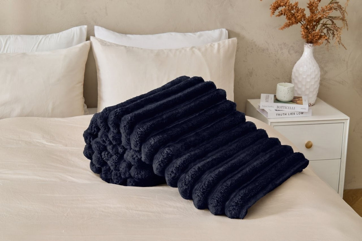 Folded chunky ribbed throws stacked to show several colours