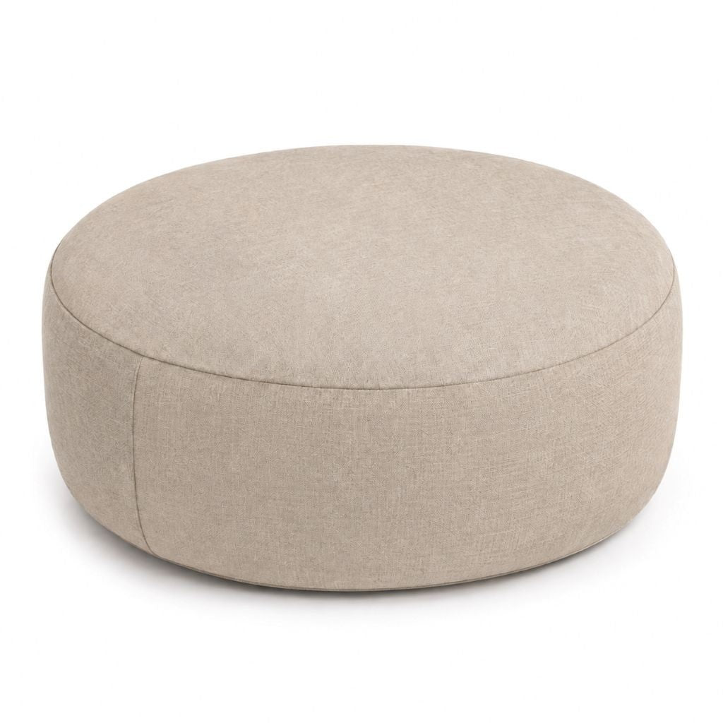 Beige round inflatable pouffe used as a footrest in a living room