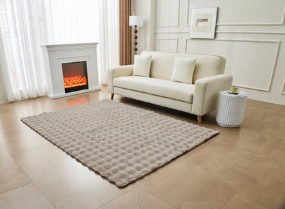 Grey faux fur rug layered on hardwood floor