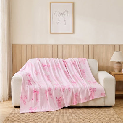 Pink Bows coquette print throw blanket styled on a bed