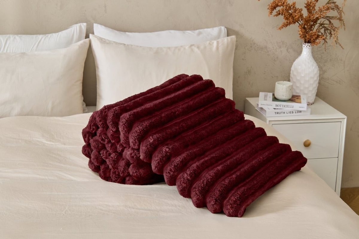 Soft ribbed throw blanket hanging over the back of a chair