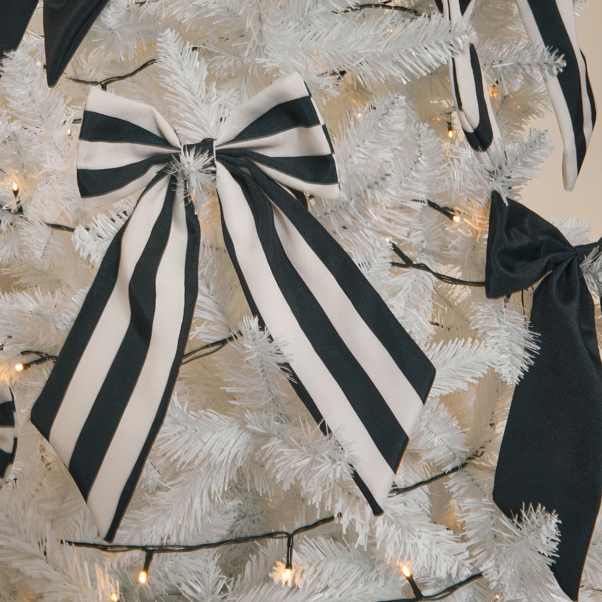 Black cream tree topper styled on Christmas tree - bows trend modern