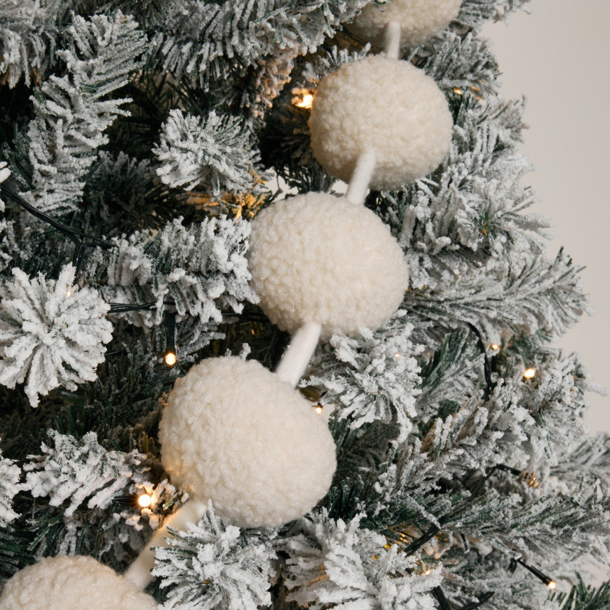 Nordic frost cream pom pom garland styled on Christmas tree