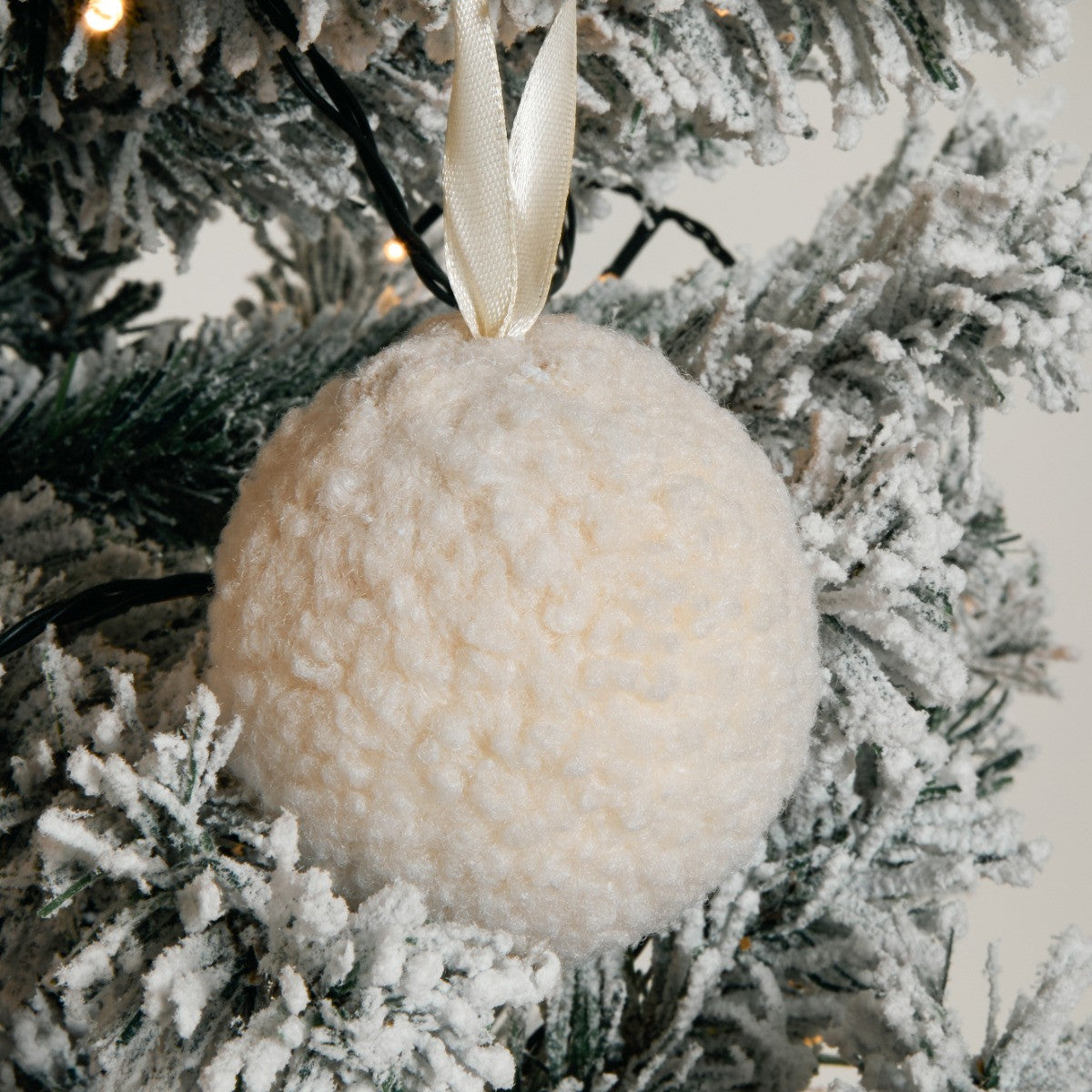 Neutral cream pom pom decorations close-up - Scandinavian Christmas